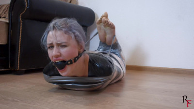 Barefoot Astrid is tightly wrapped with film and tape